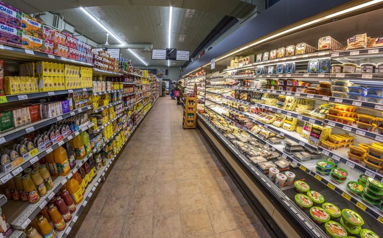 A bright supermarket aisle with well stocked shelves