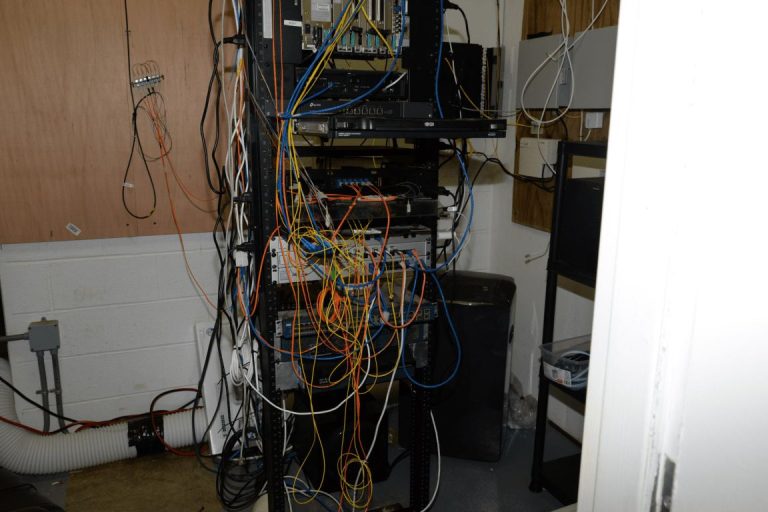 Rows of blue network cables connect servers inside a modern data centre room.